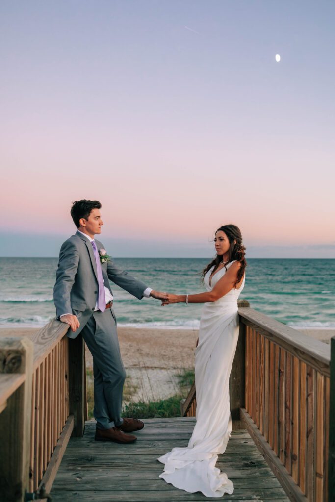 Couple holds hands on Wrightsville Beach after saying I do