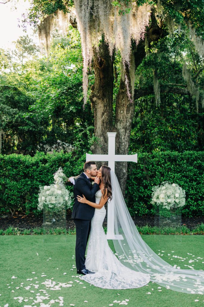 Bride and groom kiss at the altar with spanish moss at Wrightsville Manor